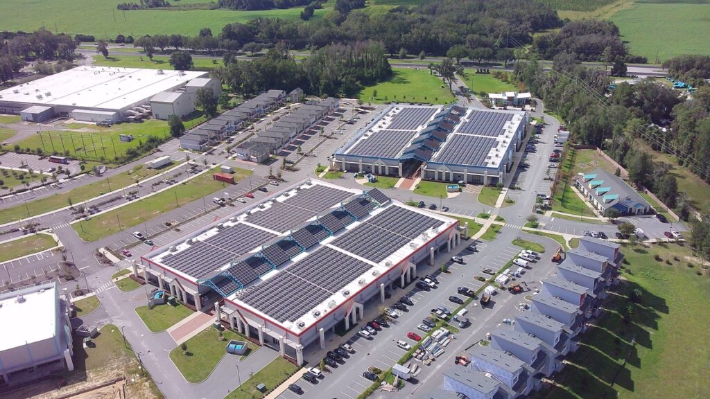 Aerial view of rooftop solar arrays on commercial buildings in a rural business park