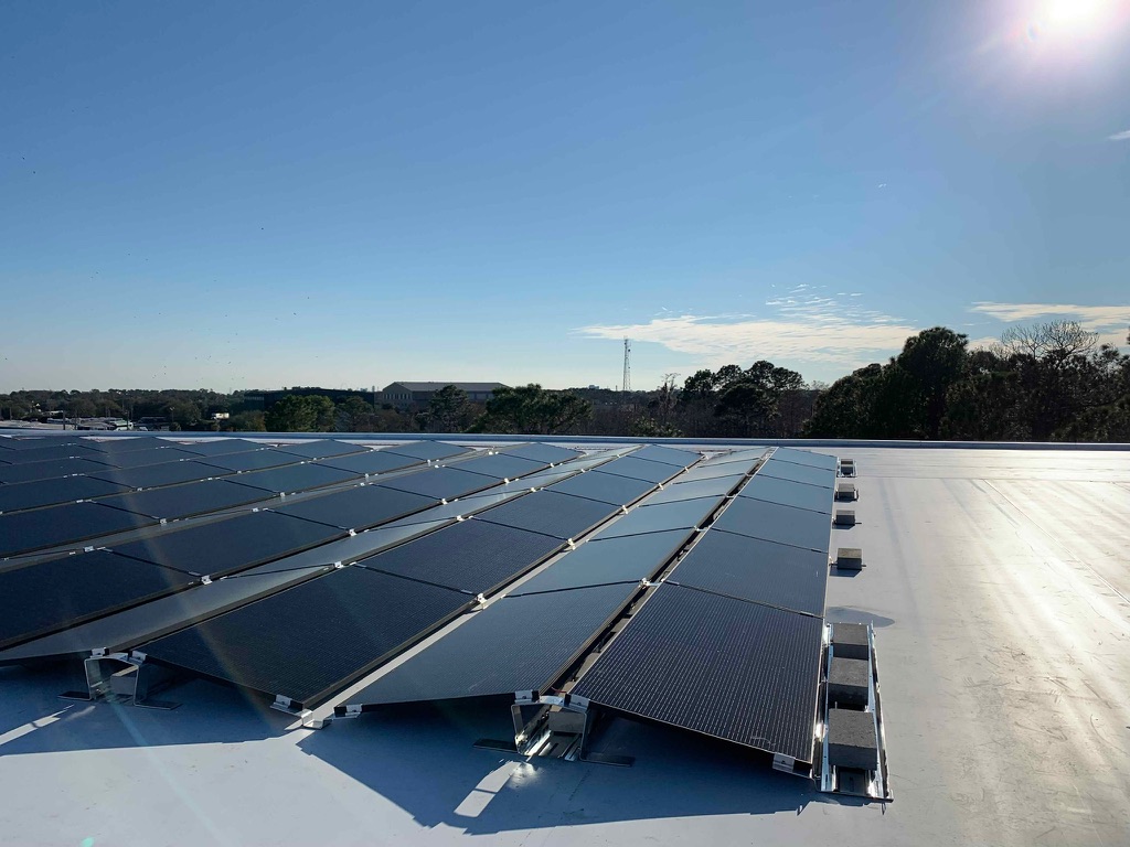 Solar panels on a flat commercial roof under a clear sky