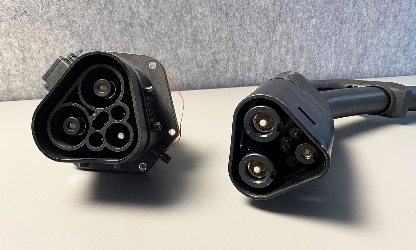 Megawatt Charging System (MCS) vehicle inlet and charging plug side by side, showing the two large DC contacts