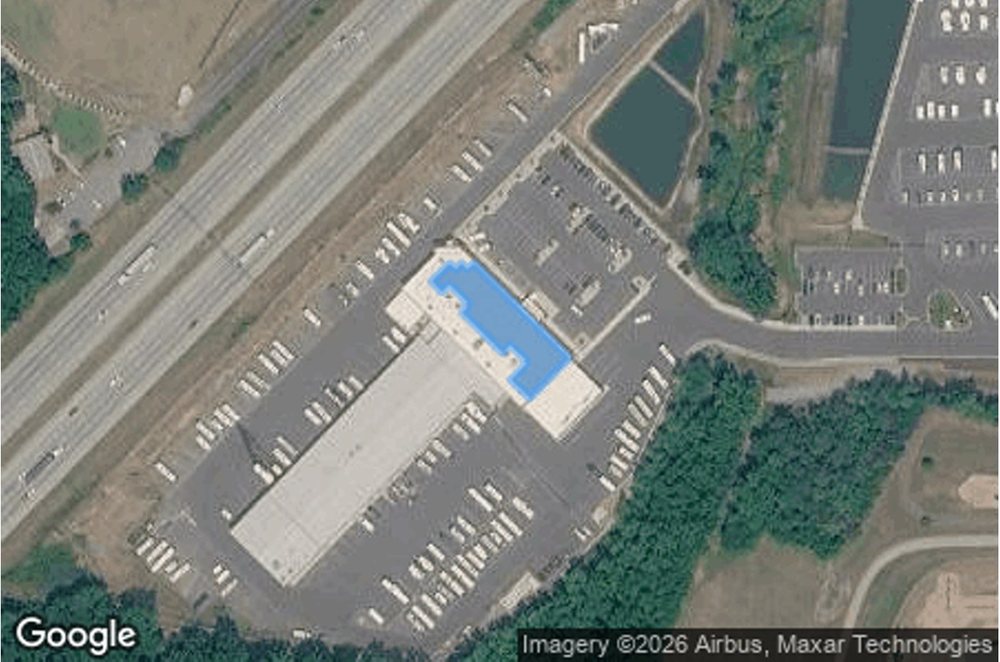 Satellite view of a commercial building with the proposed rooftop solar array outlined